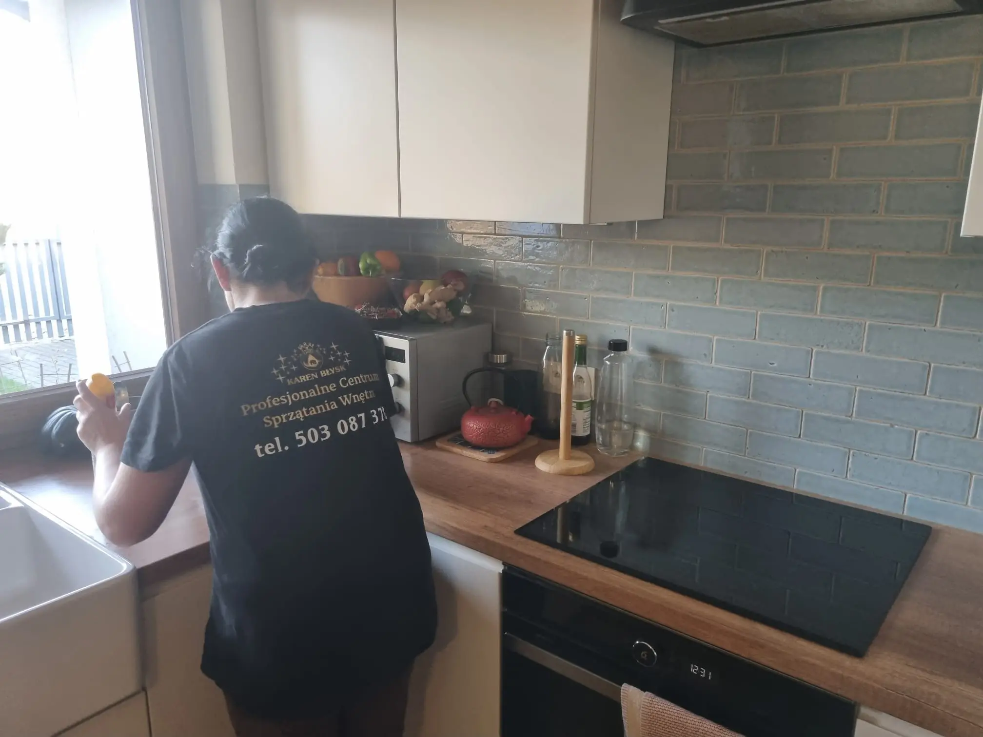 Sprzątaczka czyszcząca blat kuchenny – dokładne sprzątanie kuchni w mieszkaniach przez Karen Błysk