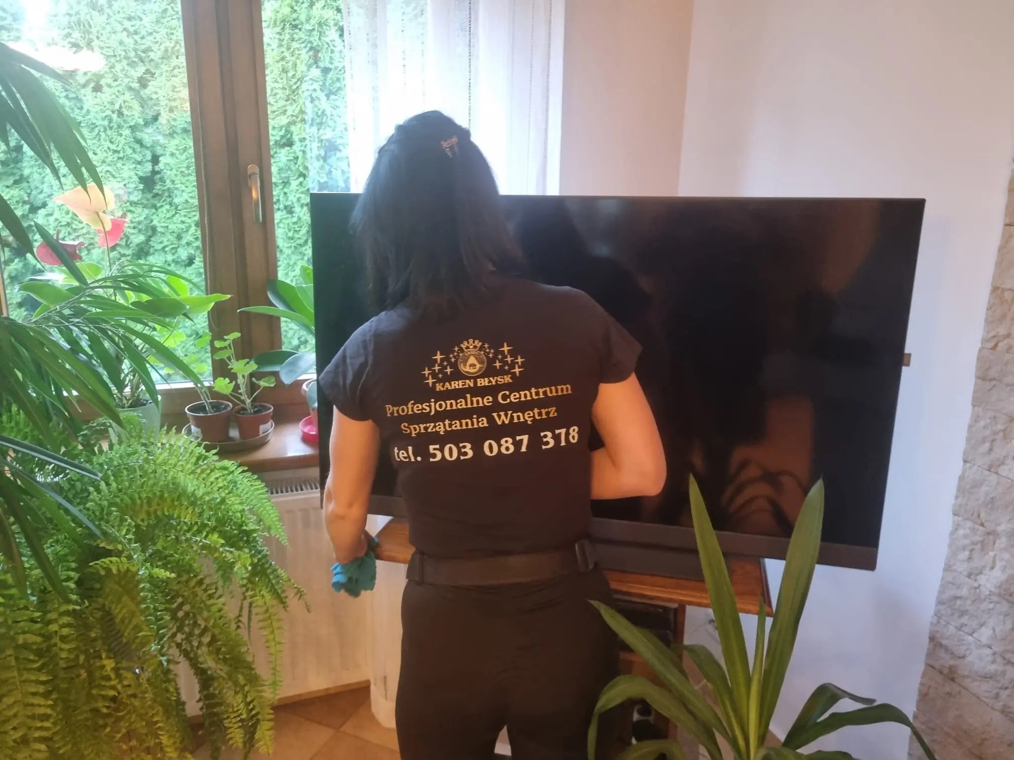 Wycieranie kurzu z szafki pod telewizorem – drobiazgowe sprzątanie salonów przez firmę Karen Błysk